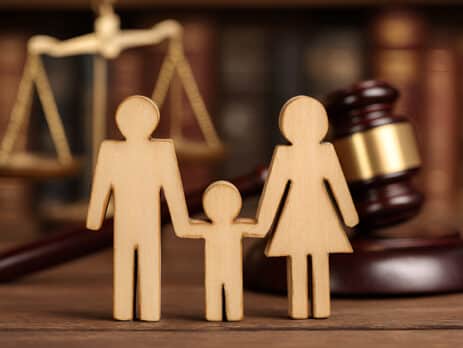 Wooden family in front of judges gavel present for a Family Law Procedure.